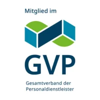 Rundes Logo mit der Aufschrift „Mitglied im GVP – Gesamtverband der Personaldienstleister“. Oberhalb des Schriftzugs befindet sich eine geometrische, aus blauen und grünen Flächen zusammengesetzte Form, die an miteinander verbundene Bausteine oder ein stilisiertes Netzwerk erinnert. Das Logo signalisiert die Verbandszugehörigkeit eines Unternehmens im Bereich Personaldienstleistungen.